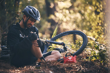 Sports man, injury and first aid outdoor while cycling on mountain bike in nature with leg or knee...