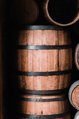 Vertical shot of a wooden wine barrel in a rustic vineyard