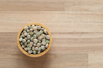 Top view of green peas in a bowl on wooden background, Healthy eating concept