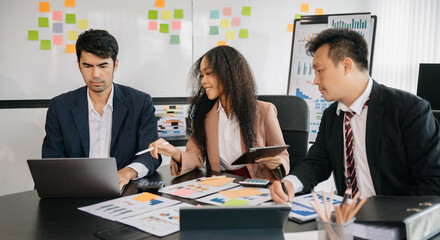 Office colleagues have a casual discussion. During a meeting in a conference room, a group of business teem sit in the conference room new startup project
