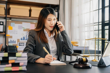 justice and law concept .Asian Feale judge in a courtroom on table and Counselor working in office.