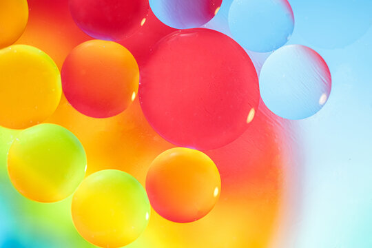 Oil drops in water and air bubbles, selective focus. Bright multicolored fantasy rainbow background. macro photo