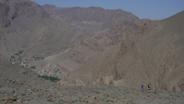 Landscape of people hiking over the Todra River on a sunny day in Morocco