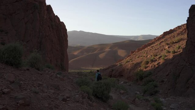 Back view of a young person with a backpack hiking in Canyon Des Doigts Du Singe in Morocco