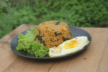 Vegetable fried rice topped with sunny side up eggs
