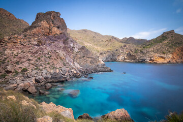 Fototapeta na wymiar Mountainous environment with cove of blue waters in the background of the coast of Cartagena, Spain, Region of Murcia