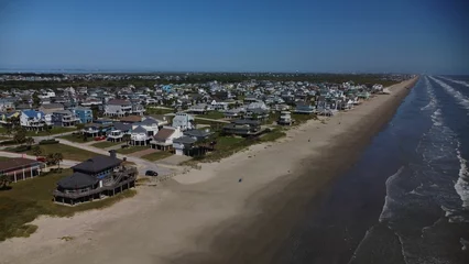 Store enrouleur Plage et mer Drone view of the resort Galveston Beach with the waves touching the wet sand beach line, Texas