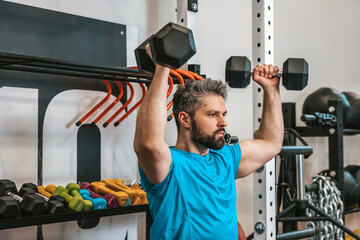 Serious athlete working with dumbbells
