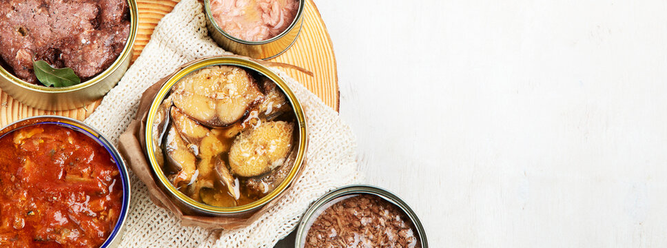 Canned vegetables, beans, fish and fruits in tin cans on a white background. Food stocks.