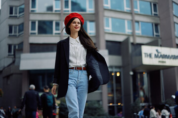 A business woman walks in the city against the backdrop of office buildings, stylish fashionable vintage clothes and make-up, spring walk, travel.