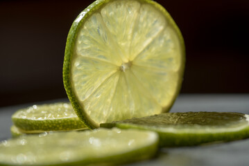 alcune belle fette di lime su sfondo scuro, foto macro alla texture delle fette di lime, il lime...
