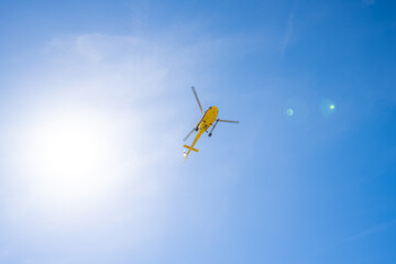 Fototapeta na wymiar Nadir shot of a helicopter flying with a clear blue sky and a ray of sunlight