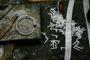 Jeweler at work in jewelry. Desktop for craft jewelry making with professional tools. Close up view of tools. Silver jewelry. Unique local artwork in Nan Province northern thailand	