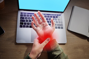 Wrist pain, hands and woman at desk with laptop, green screen and mockup with injury and red overlay. Palm, muscle tension and anatomy with health, female working night with carpal tunnel and injured