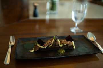 Chocolate dessert on the plate with spoon and fork