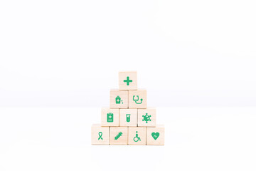 Wooden block stacking in the middle on white table and background. healthcare and medical science icon on wood cube arranged in a pyramid. copy space and isolated.