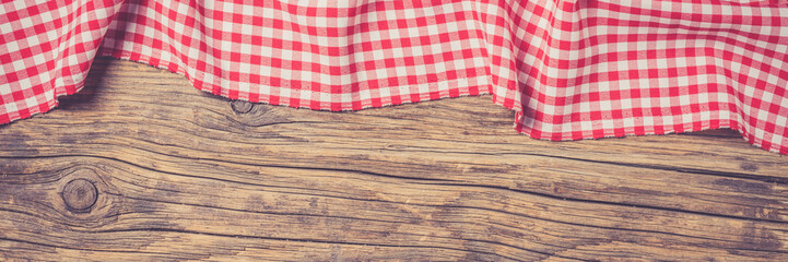 Red folded tablecloth on an old wooden table. Close up