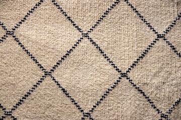 Beige fabric texture. Close-up of a light brown carpet textile background with a pattern of...