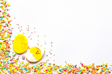 Easter decor concept. Sugar sprinkle frame with yellow egg and chick decor. Copyspace.