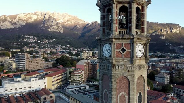 Clock tower of the Basilica of San Nicolo with the skyline of Lecco. Italy.