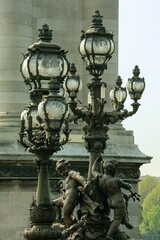 Fototapeta na wymiar Vertical closeup shot of a vintage street lap with a sculpture design in Paris, France
