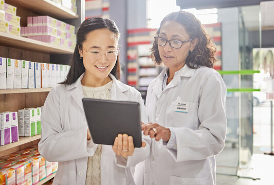 Pharmacist, tablet and teamwork of women in pharmacy for healthcare, stock take or online consultation. Telehealth, collaboration or happy medical professionals in discussion of touchscreen research.