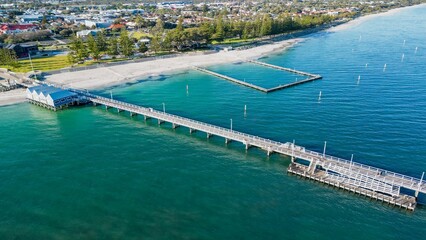 Drone shot of the Busselton Jetty on the sandy beach and the coastal buildings, Australia