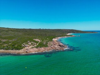 Aerial view of a shoreline of turquoise water under blue sky