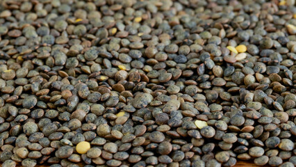 gros plan d'un tas de lentilles vertes crus sur une table en bois	