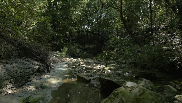 Beautiful view of woods in Lost Creek in Allen TX with river,rocks and light falling from the trees