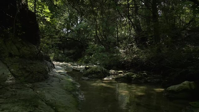 Beautiful view of woods in Lost Creek in Allen TX with river, rocks and light falling from trees