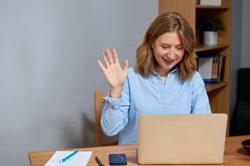 Close up of a beautiful young blonde woman at home, having videocall on laptop.