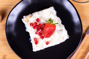 Güllaç dessert with pomegranate and strawberry. Ramadan dessert. Gullac dessert with walnuts on wooden background. Top view