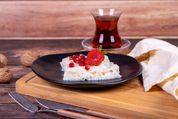 Güllaç dessert with pomegranate and strawberry. Ramadan dessert. Gullac dessert with walnuts on wooden background.