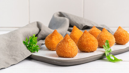 Traditional fried coxinha de frango - croquette of chicken on the white table, Brazilian snack.