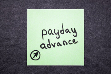 Payday advance written note, text concept PAYDAY ADVANCE.