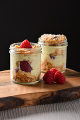 Italian dessert. Raspberry Panna cotta with raspberry jelly on a dark background. Berry dessert with cream sauce in small jars.