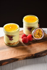 Vegan Panna Cotta sweet dessert with passion fruit, garnish with fresh mint leaf. Homemade recipe, dark background
