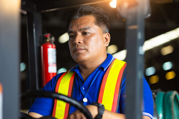 Asian man warehouse worker drive forklift in warehouse. Warehouse staff worker  by goods shelf working in large warehouse factory