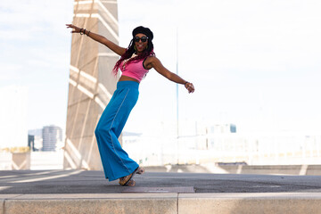 Fototapeta na wymiar Black woman on roller skates riding outside on urban street. Modern woman posing on roller skates..