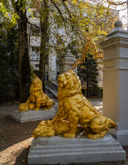 Arch with Figures of two golden lions on huge slabs. Medical park of resort town Goryachiy Klyuch. Monument of architecture. Arch was built in 1914. Under front paws of lions are dead wild boars..
