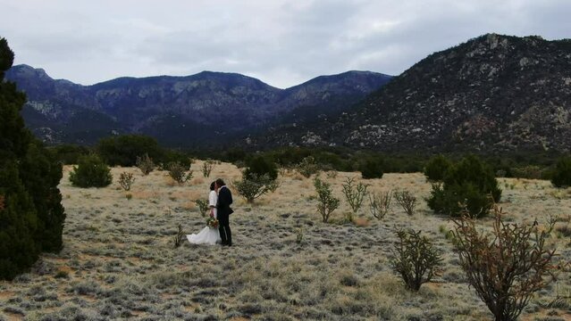 Romantic fog dancing wedding couple aerial pan right slow Sandia Mountains Albuquerque New Mexico