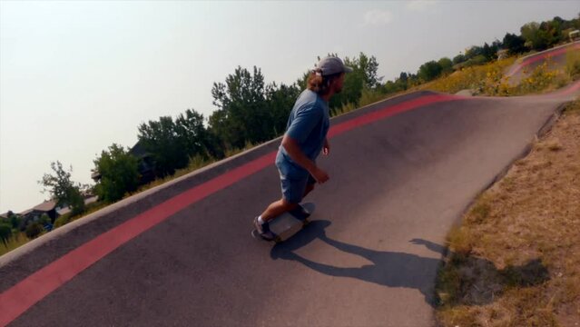 Colorado male skateboarder pump track fast skate around corners