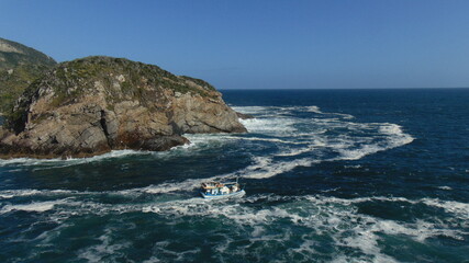 fishermen boat facing the strong sea in arraial do cabo brazil