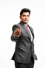 Young indian businessman pointing in front off with finger.