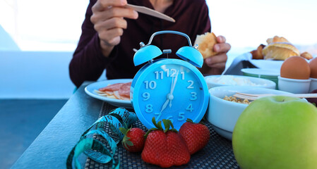 Blue alarm clock Intermittent fasting method - sixteen hours diet, eight hours eating time. Healthy lifestyle concept
