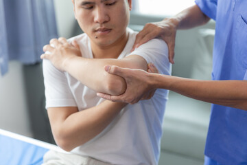 Obraz premium Doctor or Physiotherapist working examining treating injured arm of athlete male patient, stretching and exercise, Doing the Rehabilitation therapy pain in clinic.