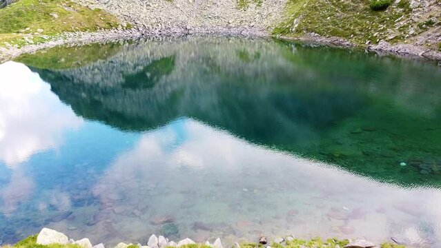 Close Up Drone Flight Over A Clear Turquoise Mountain Lake With Limestone Pebbles And Green Grass, Iezer Lake, Transylvania, Romania
