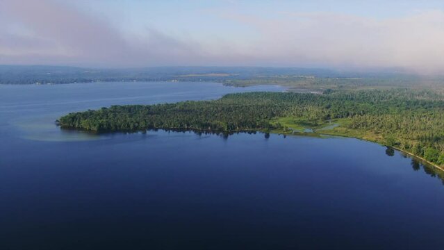 Lake shoreline green blue early morning fog Burt Lake Up North Great Lakes Petosky Harbor Springs Mackinaw cottage farmland backward movement Michigan