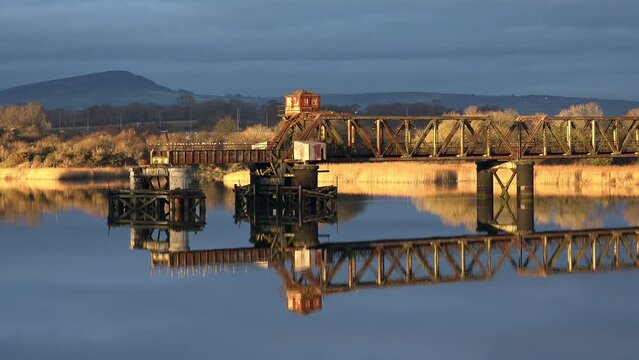 Golden hour Waterford red iron bridge sunset on a cold winter evening with very still river water